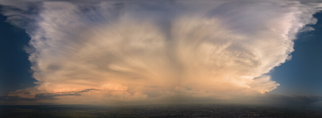 Panoramic view of a dramatic, expansive cloud formation over a landscape, capturing the stunning...