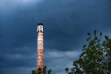 Cellular base stations on a brick old chimney of an abandoned factory. Telecommunications radio...