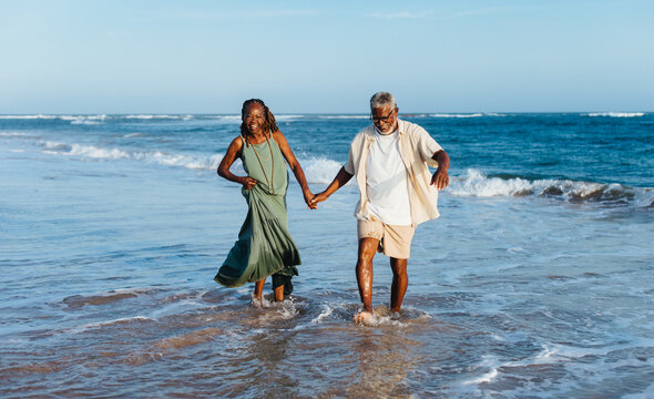Joyful senior couple walking by the sea