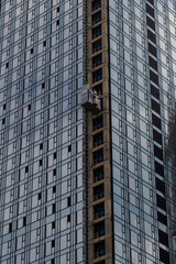 Close-up side view of blue glass wall of modern skyscraper building under construction. Copy space. Abstract construction background. Housing development theme.