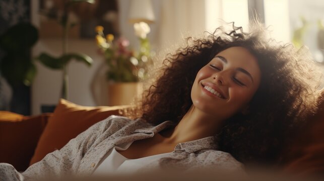 Happy woman relaxing on the sofa at home - Smiling girl enjoying day off lying on the couch, Healthy life style, good vibes people and new home concept