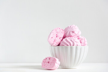 pink strawberry marshmallows in a beautiful white plate on a white background