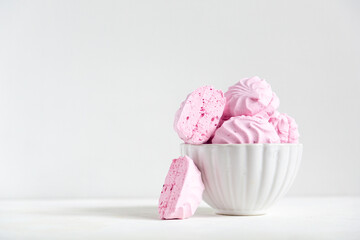 pink strawberry marshmallows in a beautiful white plate on a white background