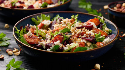 Warm baked carrots and beetroot salad with feta cheese and roasted hazelnuts