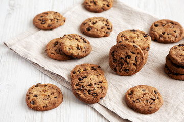 Homemade Gooey Chocolate Chip Cookies on a white wooden background, side view.