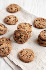 Homemade Gooey Chocolate Chip Cookies on a white wooden background, side view.