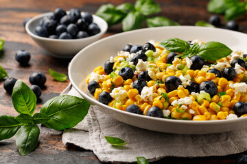Blueberry Corn Feta Salad in white plate on wooden table. Healthy food