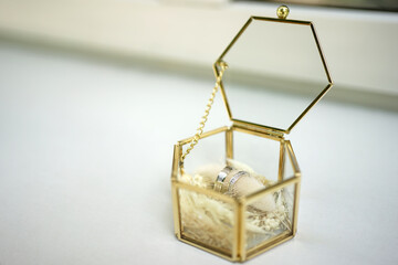 Two white gold wedding rings in a glass box.