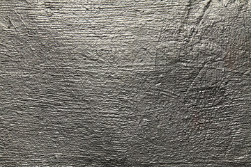 Silver metallic wall, background, texture. Uneven, grooved and embossed silvery backdrop. Grey...