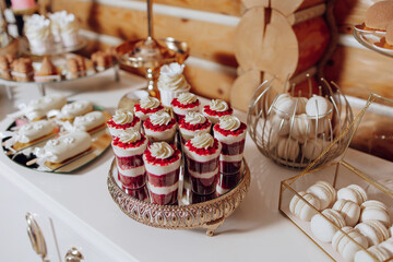 A table with a variety of desserts, including cupcakes and macaroons. The desserts are arranged on a tray and are displayed in a way that makes them look appealing and inviting