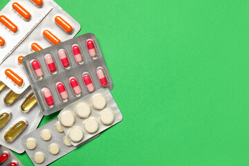 Blister packs with different pills on green background