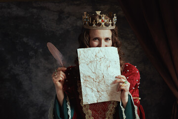 medieval queen in red dress with parchment and crown