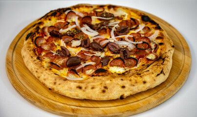 Calabrian sausage pizza served on a round board and set table