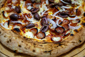 Calabrian sausage pizza served on a round board and set table