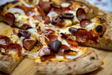 Calabrian sausage pizza served on a round board and set table