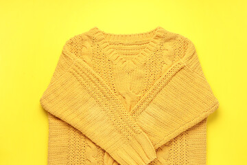 Stylish female sweater on yellow background