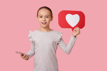 Little girl with heart like icon and mobile phone on pink background