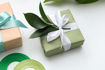 Gift boxes with leaves on white background. International Women's Day