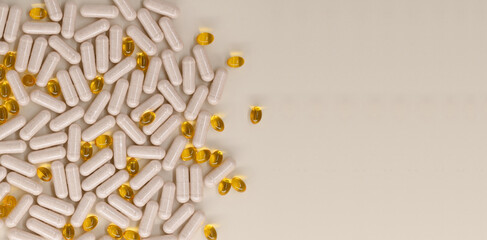 Multicolored pills and vitamins on pastel beige background, top view with copy space