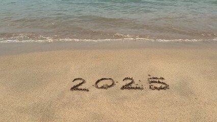 2025 inscription on sand, sea or ocean 