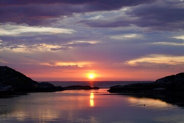 Fototapeta premium Scenic view of sunset colors is displayed over the ocean outside Kristiansund, Norway.