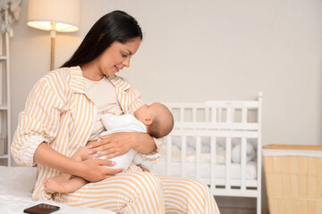 Mother breastfeeding her baby in bedroom