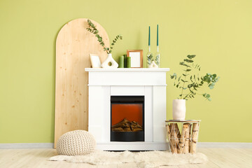 Coffee table with vase of eucalyptus branches near fireplace in living room