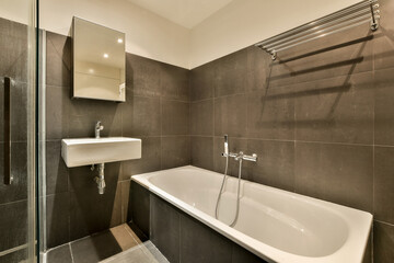 Modern bathroom with dark tiles in Henkenshage, Amsterdam
