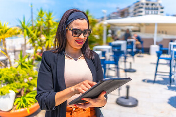 Businesswoman standing using digital tablet on a luxury terrace