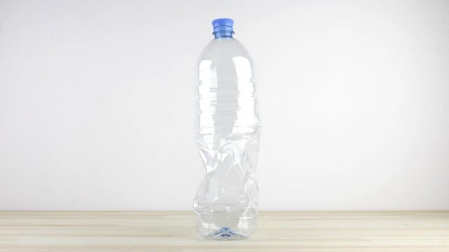 Empty plastic bottle folding down and unfolding back seamless loop cycle stop-motion. Recycle concept
