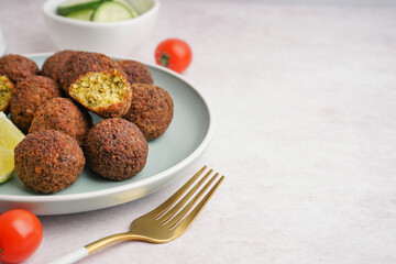 Plate with delicious falafel balls and tomatoes on light background, closeup