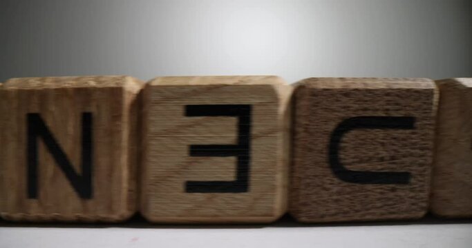 Line made of wooden cubes with letters of English alphabet. Incorrectly inverted blocks with ABC letters stand on white surface in wrong order