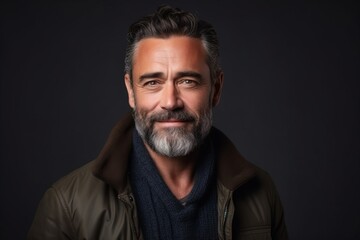 Fototapeta premium Portrait of a handsome middle-aged man with grey beard and mustache wearing a warm jacket.