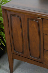 Vintage walnut credenza with a decorative modern design. Close-up detail product photograph.