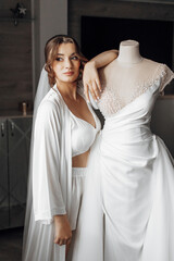 Naklejka premium A woman in a wedding dress is getting her dress altered by a woman in a black dress. The scene is set in a room with curtains
