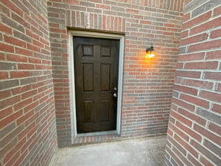 House front entrance surrounded of a red brick wall.