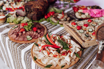 A table is covered with a variety of food, including meat, vegetables, and bread