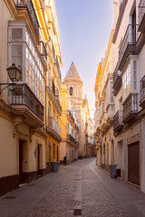View of a deserted old narrow cobbled street early in the morning. Cadiz. Spain. © Kavalenkava