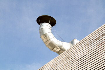 Kitchen ventilation chimney made of metal, on the roof of the building