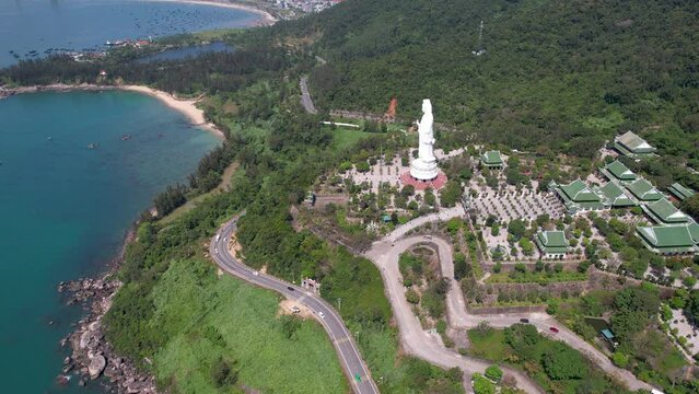 Forward reveal aerial shot of Chua Linh Ung Buddhist temple on sunny day. Da Nang, Vietnam.