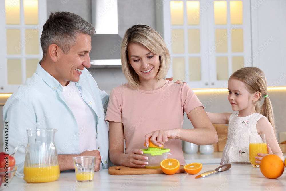 Sticker Happy family making juice at white marble table in kitchen