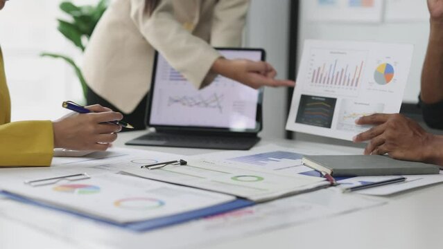 Investment analyst working in office. Meeting financial advisor analyzing financial charts in business report and planning financial budget. Team of auditors is doing accounting work in the office.