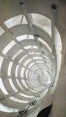 High angle view of multi level parking ramp spiral illuminated by lights. Modern building concept