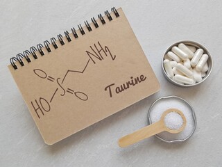 Structural chemical formula of taurine (2-aminoethanesulfonic acid) written on a notebook with...