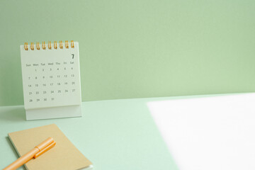 Calendar and notepad, pen for schedule, business, vacation plan on mint green desk background