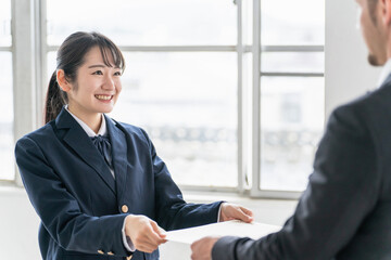 卒業式に卒業証書を渡す先生と受け取る生徒（女子高生・高校生・中学生）
