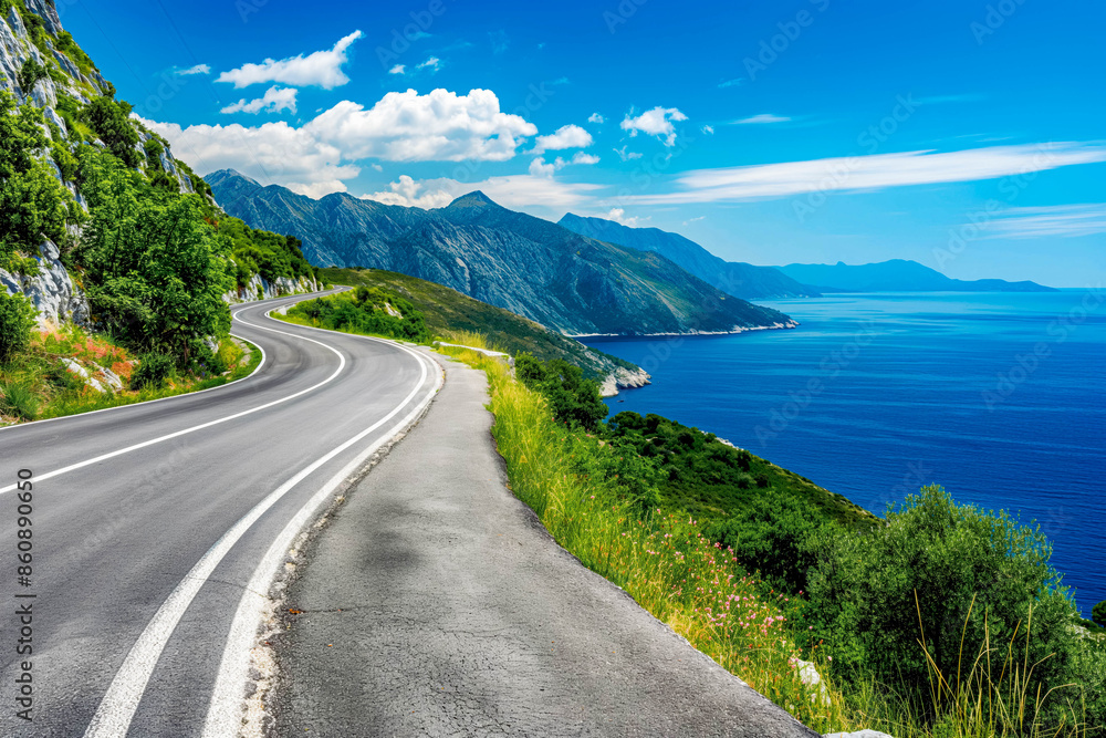 Wall mural Turning mountain highway with blue sky and sea on a background