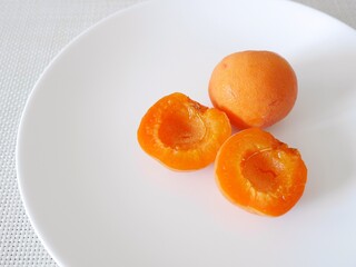白い皿の上の日本の生食用あんず「ニコニコット」（断面）