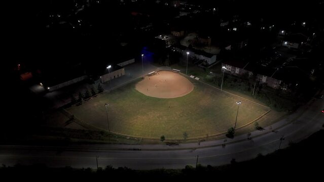 Aerial view of a baseball field at night with players playing American baseball.Canada.Halifax.Men and women play baseball. Catcher learns to catch a baseball while throwing a ball 