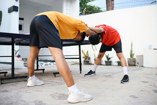 Full Length Of Two Young Asian Guy Cooling Down Together Holding Shoulder And Bending Body.
